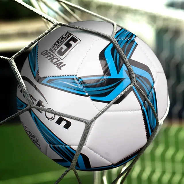 A soccer ball in the back of the goal net